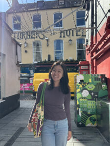 A smiling student with a grocery bag in Cork, Ireland.