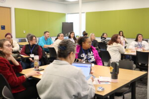Participants in UMW's Maker Mindset Conference sit around tables listening to a speaker.