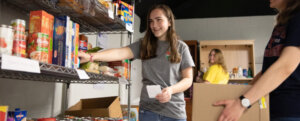 Photo of student stocking shelves at UMW's food pantry