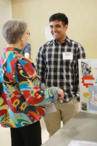 A smiling student talking to a donor.
