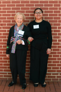 A donor and student standing in front of a brick wall.