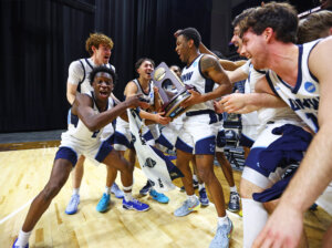 Photo of UMW basketball players holding a trophy