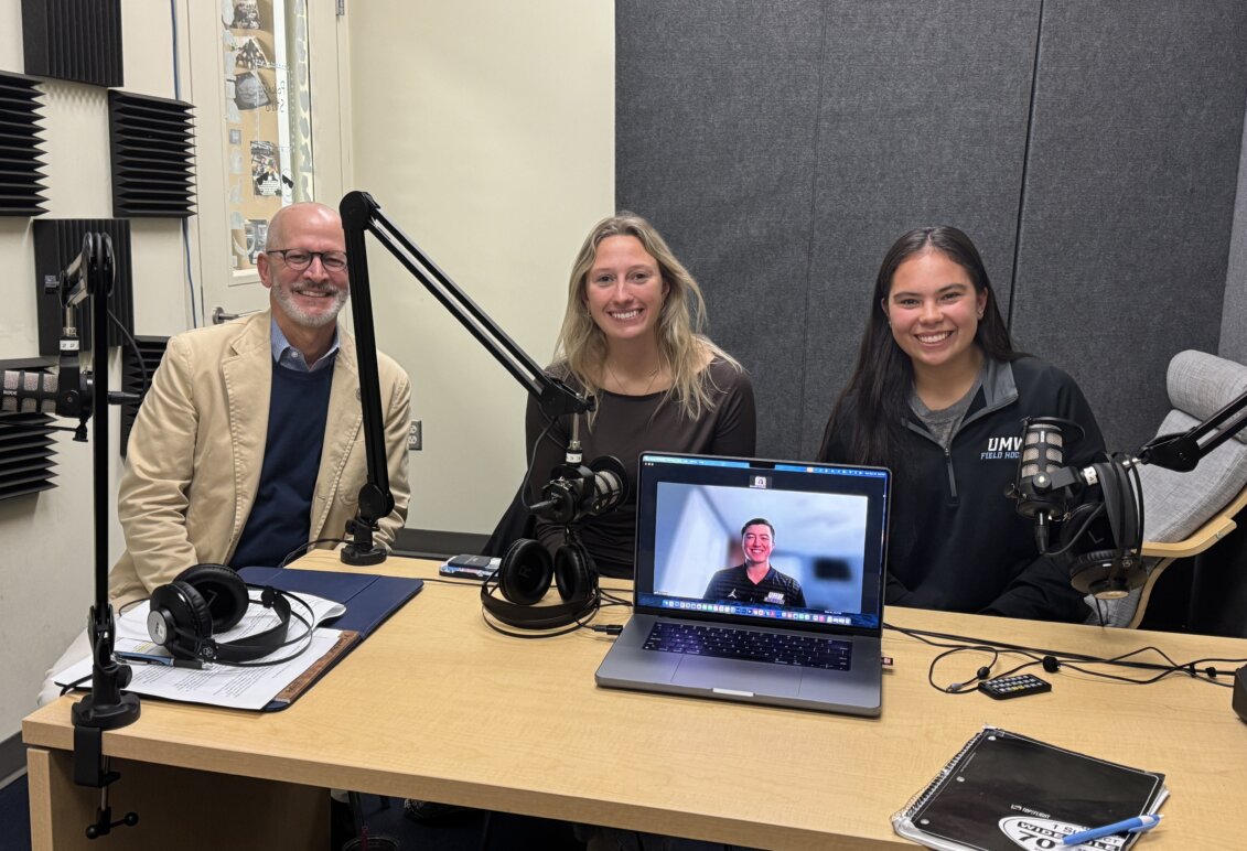 Photo of three people at a desk with another person appearing on a laptop screen on the desk. Photo includes student co-president's of SAAC with UMW President Troy Paino.