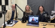 Photo of three people at a desk with another person appearing on a laptop screen on the desk. Photo includes student co-president's of SAAC with UMW President Troy Paino.