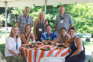 Photo of a group of people at a picnic table during reunion weekend in 2024 on Ball Circle that include Lou Marmo and his college roommate Chris Houchins.