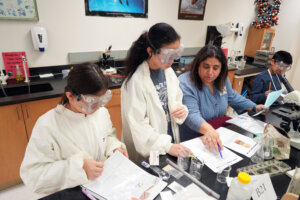 Arya Meggers, 12 (left), and Angelina Song-Ye, 13, from Kilmer Middle School in Vienna, compete in the Crime Busters category at the Virginia Science Olympiad. Photo by Suzanne Carr Rossi.