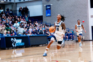 Photo of UMW junior guard Kaden Bates driving to the basket.