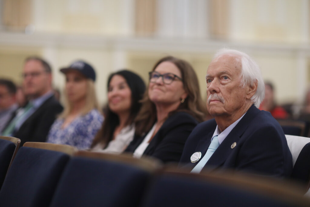 A close-up of several people sitting in an auditorium
