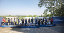 People stand in a line holding shovels