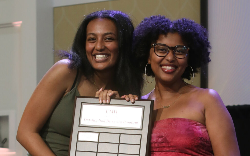 Two women hold an award