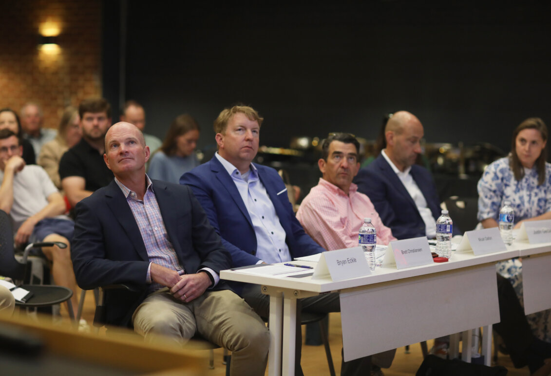 Four men and one woman sit at a judges table