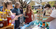 Photo of students shopping at a vendor's booth selling honey and miscellaneous items