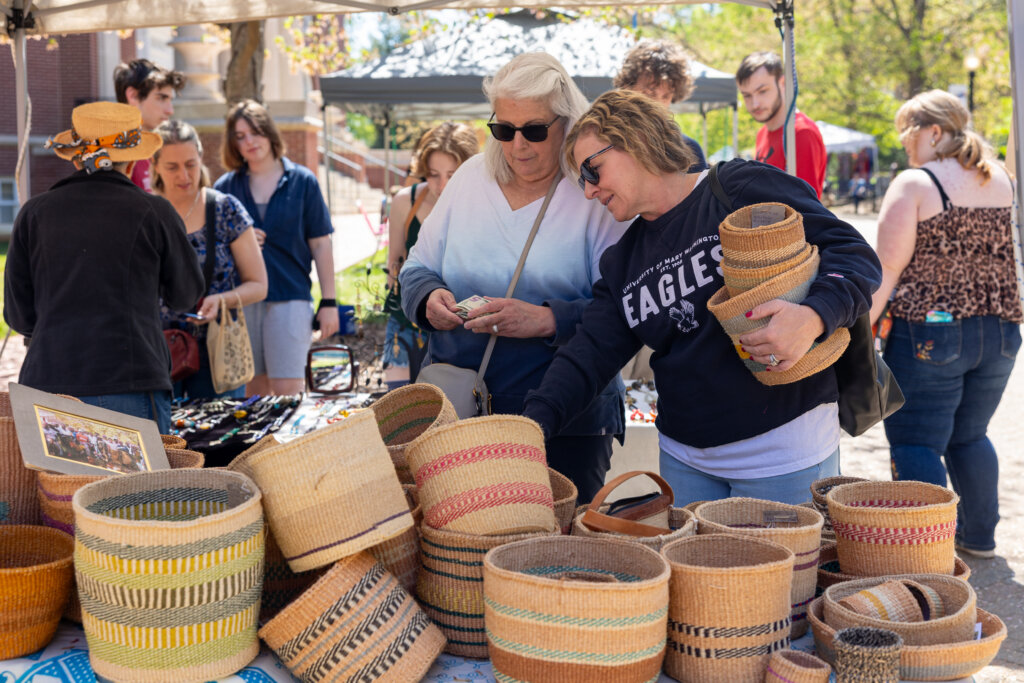 Two women look at baskets to purchase