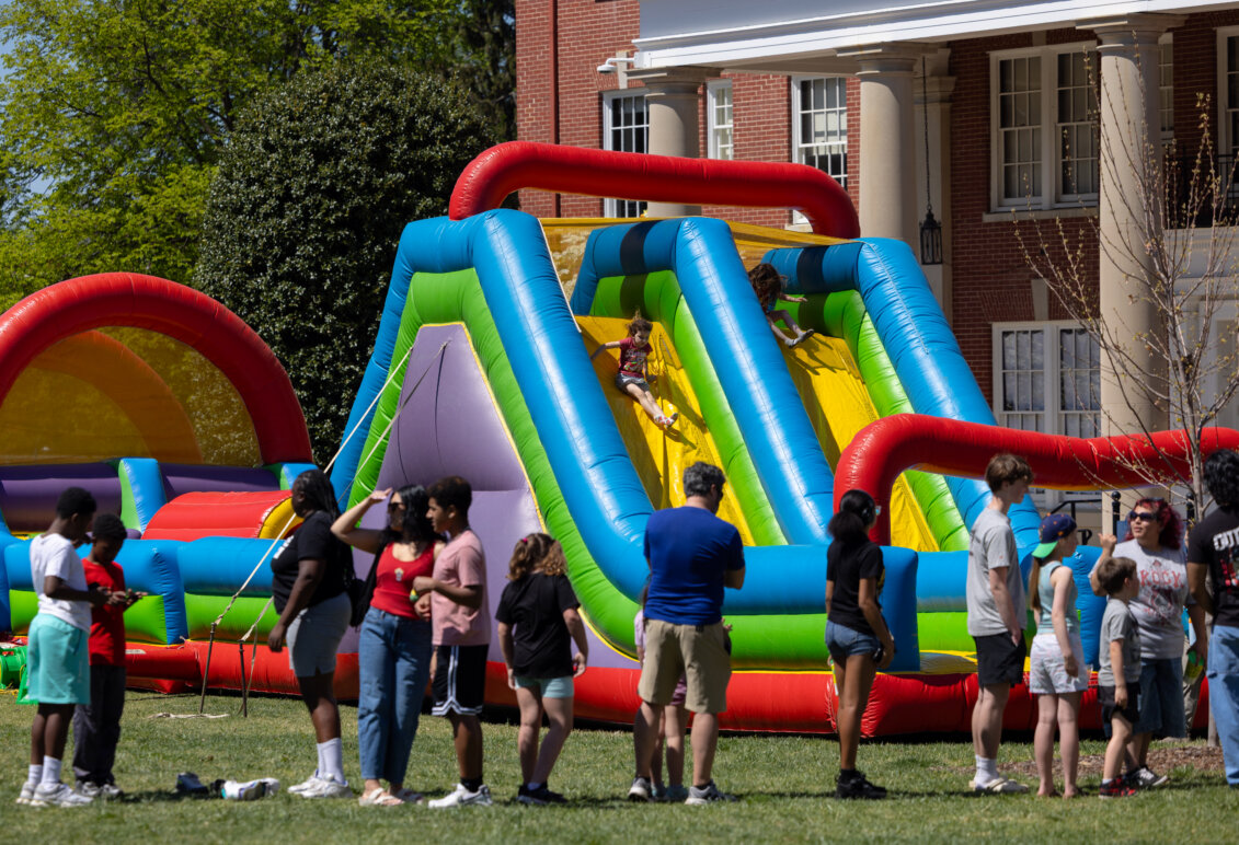 Children play on a large inflatable object set up on the lawn