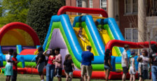 Children play on a large inflatable object set up on the lawn