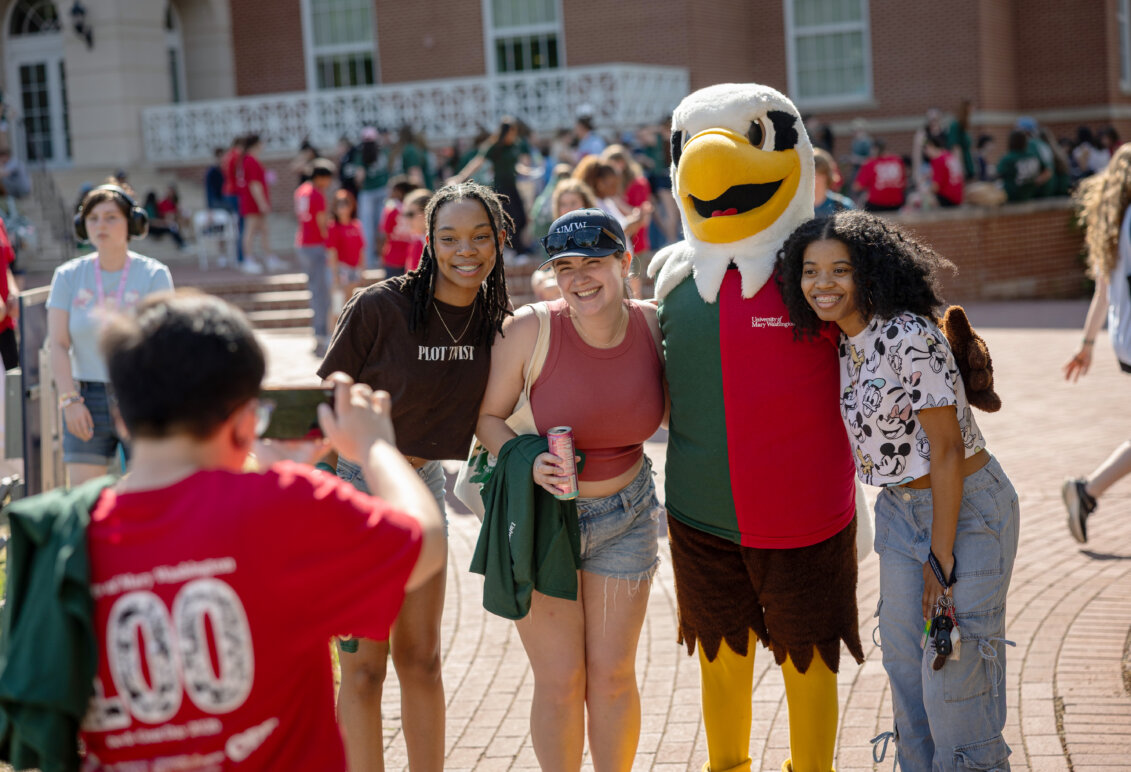 a mascot dressed as an eagle is surrounded by students