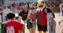 a mascot dressed as an eagle is surrounded by students
