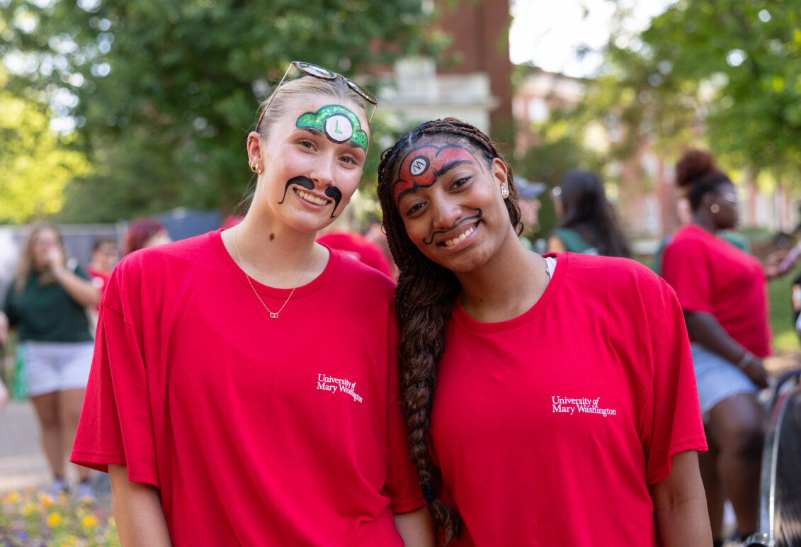two girls dressed in red and wearing face paintings