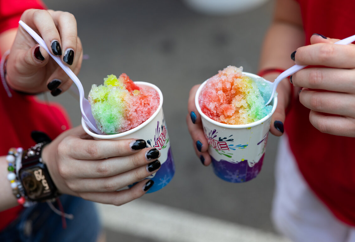 two colorful snow cones with plastic spoons