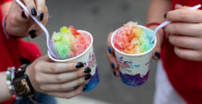 two colorful snow cones with plastic spoons