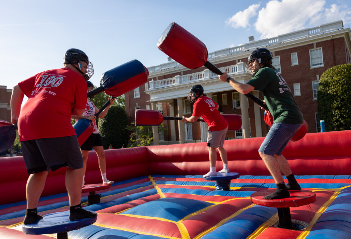 four people joust on an inflatable court