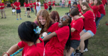 people dressed in red play tug-of-war