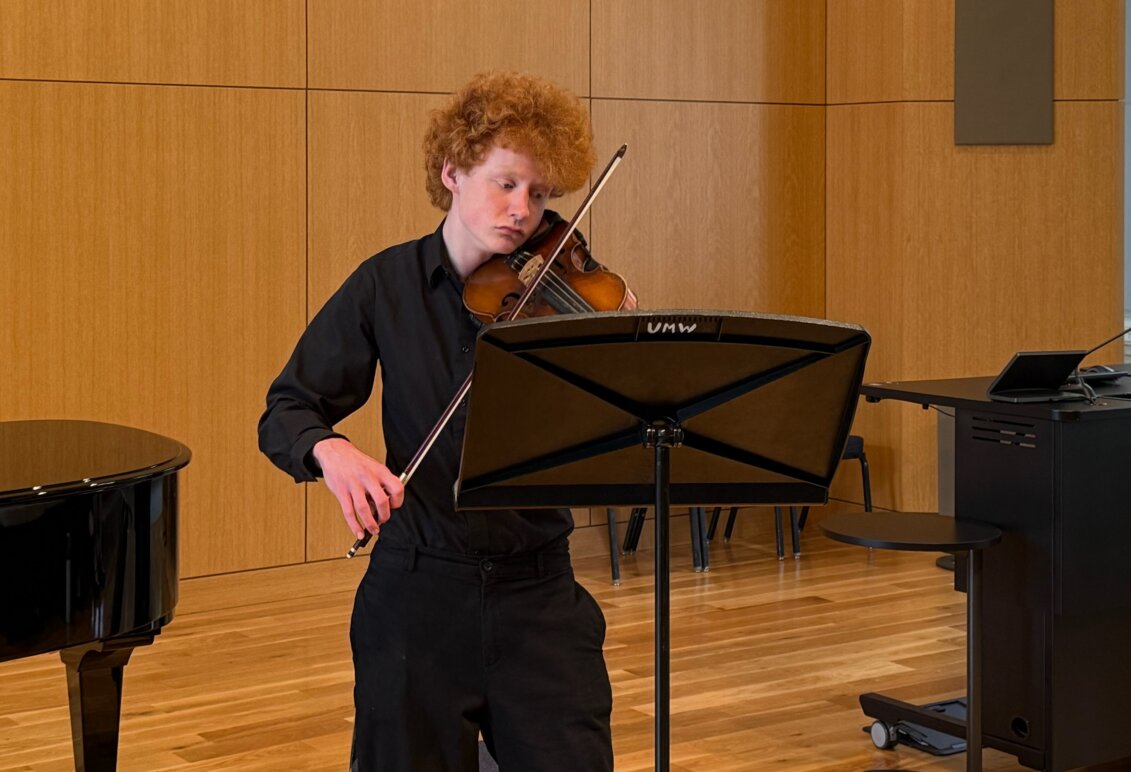a student plays the violin during a performance