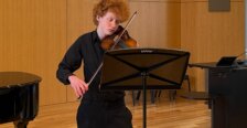 a student plays the violin during a performance