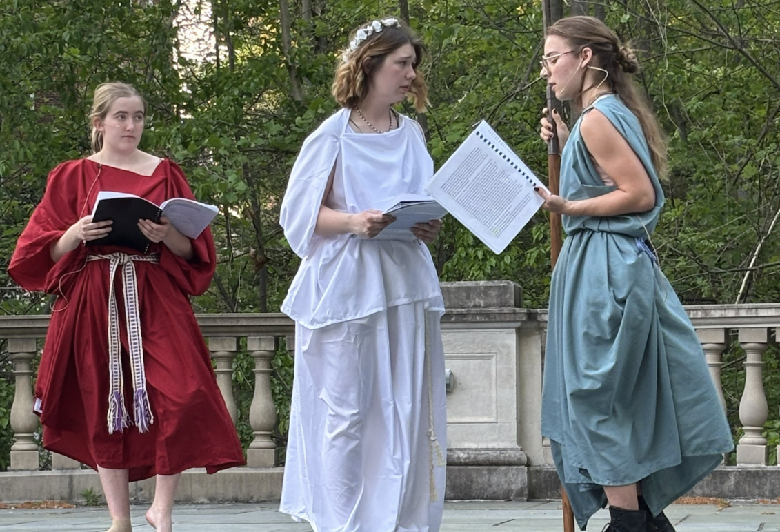 Students in costume performing a Greek play on outdoor stage