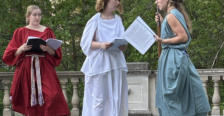 Students in costume performing a Greek play on outdoor stage