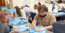 Students sit at a table making crafts