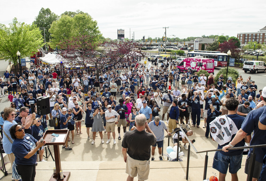 A huge crowd at a celebration fans out across a parking lot