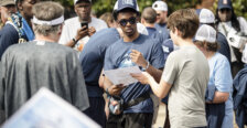 A fan asks a basketball player to autograph a poster