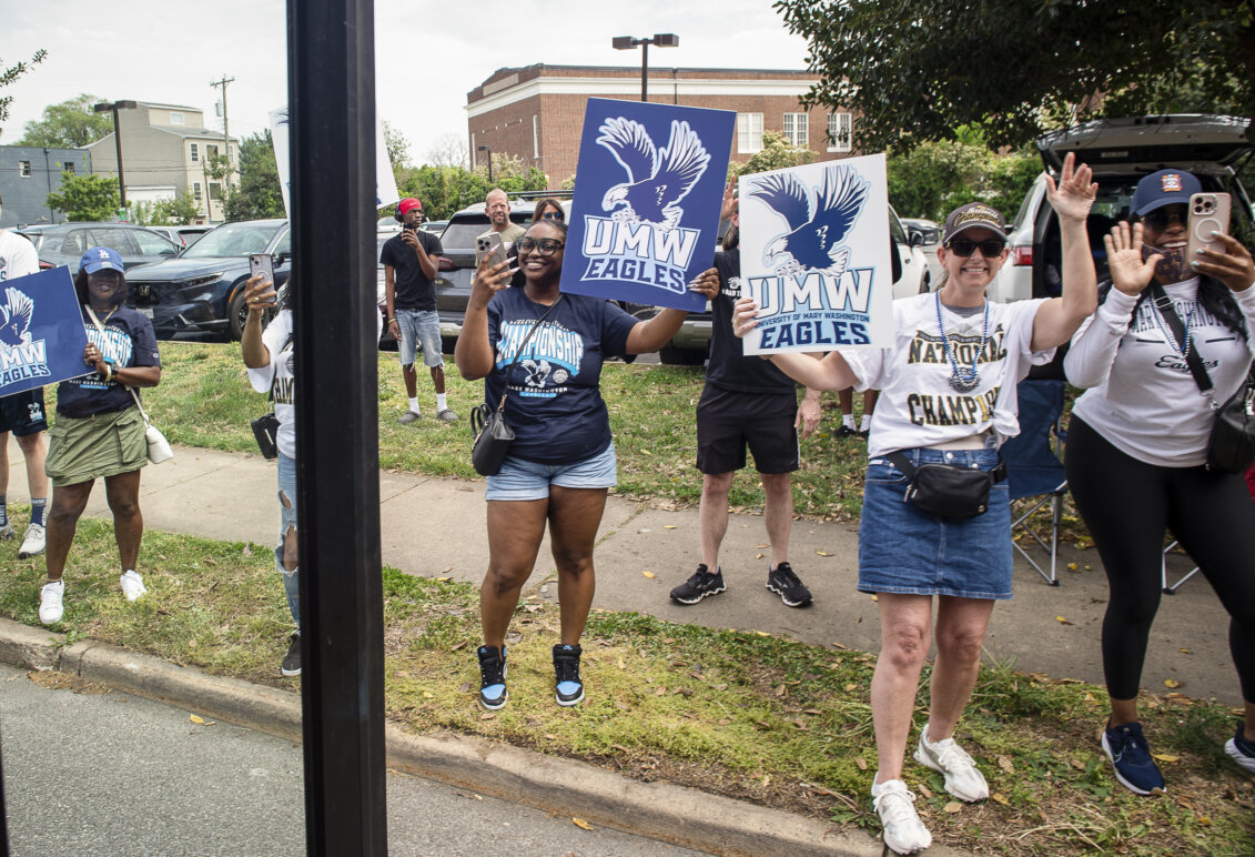 Several people on a city street hold celebratory posters