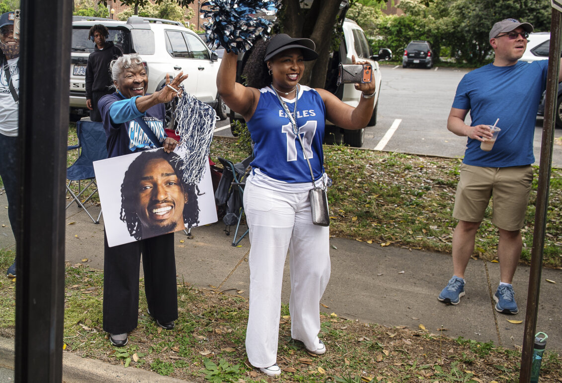 Women hold pompoms and signs in celebration