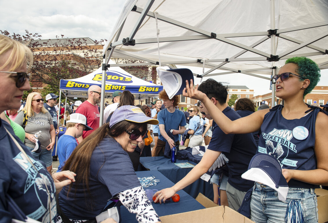 People stand under tents with spirited T-shirts to give away