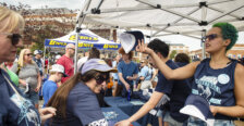 People stand under tents with spirited T-shirts to give away