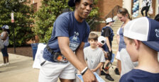 A basketball player signs an autograph for a child