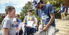 A basketball player signs an autograph for a child