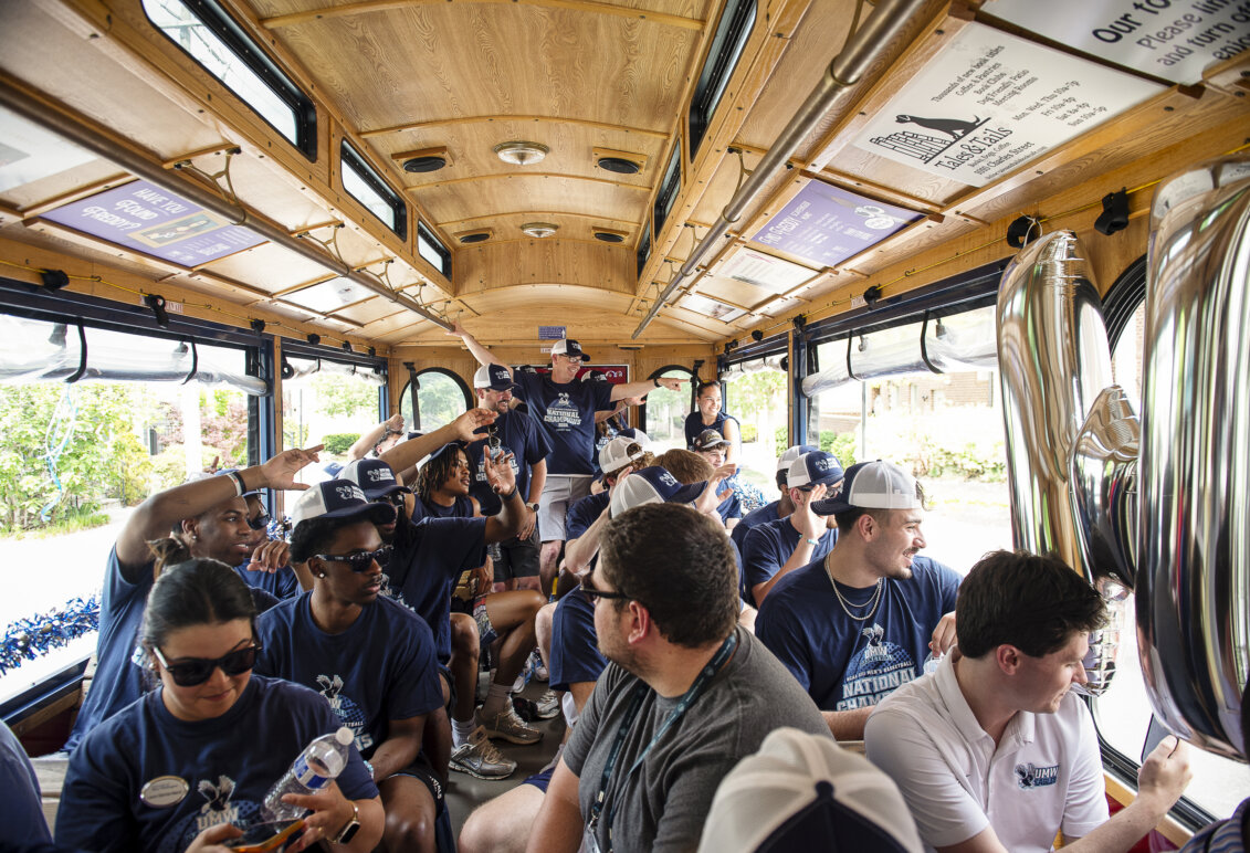 A basketball team is shown riding inside a trolley