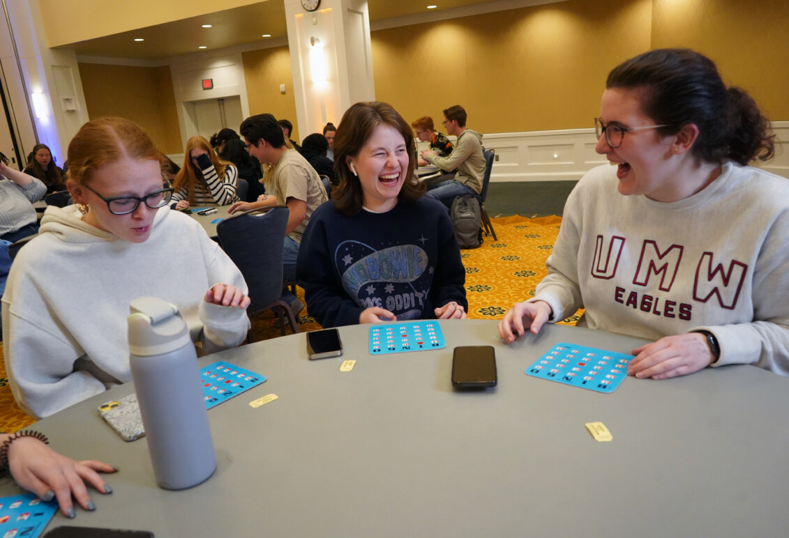 Students sit at a table playing Bingo