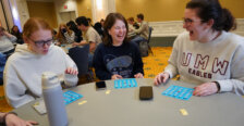 Students sit at a table playing Bingo