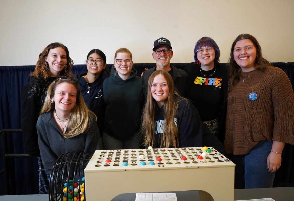 A group of people stand behind a Bingo board