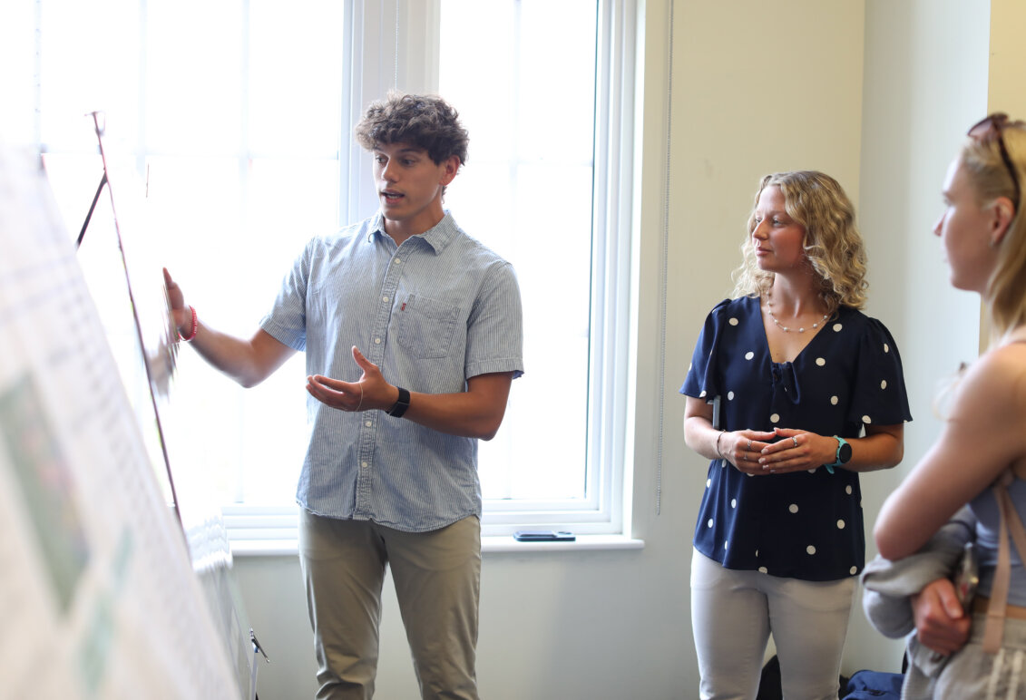 Seniors Larry Almariento and Reagan Makfinsky stand in front of their poster presenting