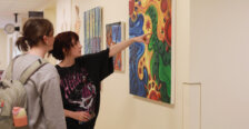 two students admire artwork on the wall on campus