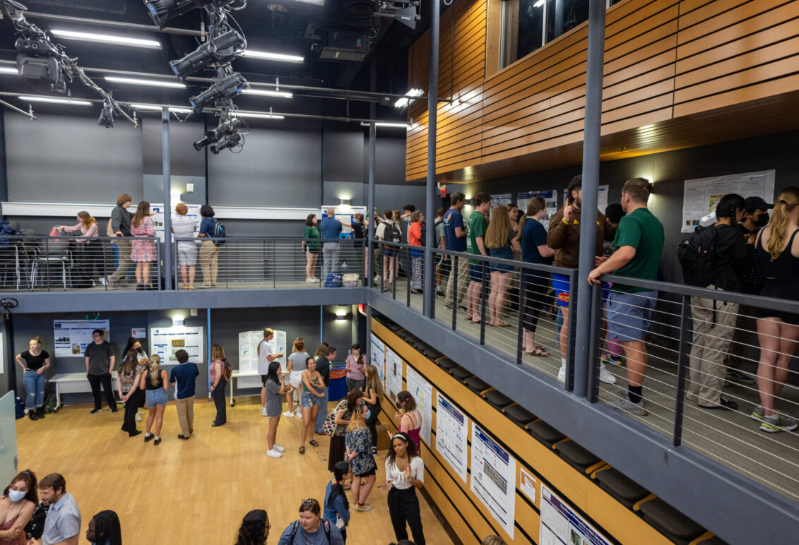 A crowd is gathered in the Digital Auditorium  to view and present posters during Research and Creativity Day