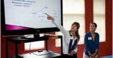 A student points to a presentation on a screen