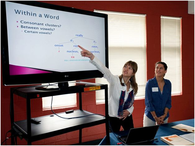 A student points to a presentation on a screen