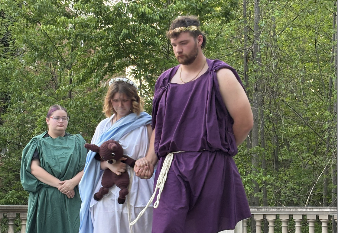Students in costume performing a Greek play on outdoor stage