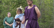 Students in costume performing a Greek play on outdoor stage